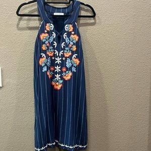 Navy blue dress with pinstripes and embroidered flowers.